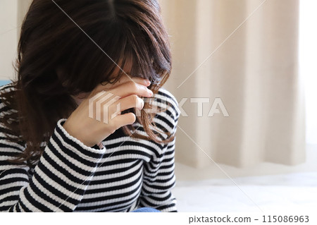 A woman holding her head worried image 115086963