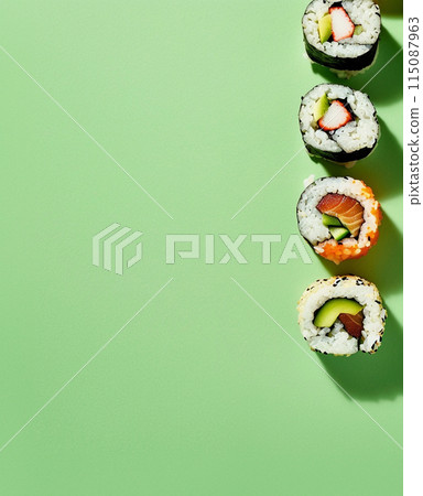 Set of sushi rolls top view over soft green background 115087963