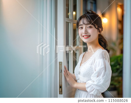 Smiling woman opening the door 115088026