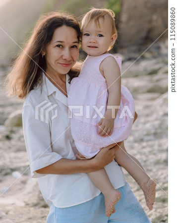 Cute child girl eat apple fruit. Little girl close up in summer garden. 115089860