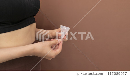 Mockup Silicone Menstrual Cup In Hands Of Woman Wearing Yoga, Sport Suite On Brown Background. Eco Friendly Concept, Easy Doing Yoga During Menstruation, Horizontal Plane, Copy Space Mockup Silicone Menstrual Cup In Hands Of Woman Wearing Yoga, Sport Suite On Brown Background. Eco Friendly Concept, Easy Doing Yoga During Menstruation, Horizontal Plane, Copy Space 115089957