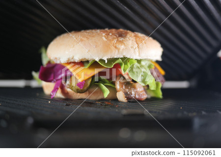 Sandwich with meatballs, lettuce, and red cabbage grilling at home  115092061