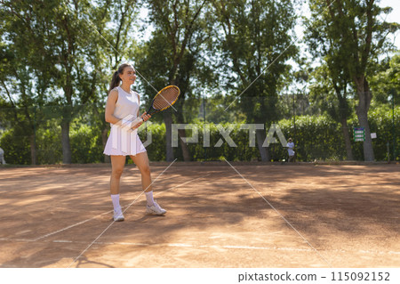 A woman is playing tennis on a court A woman is playing tennis on a court 115092152
