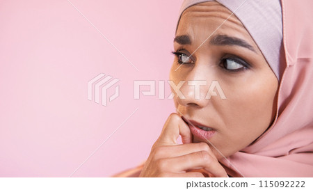 Scared face. Fear anxiety. Concerned expression. Overwhelmed worried confused pensive woman in hijab isolated on pink empty space background. Scared face. Fear anxiety. Concerned expression. Overwhelmed worried confused pensive woman in hijab isolated on pink empty space background. 115092222