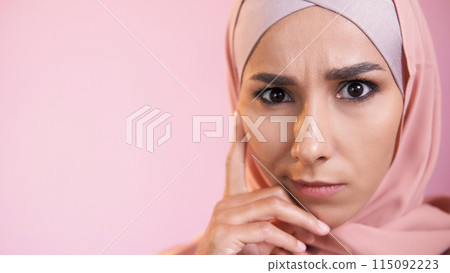 Confused face. Pensive expression. Portrait of concerned serious skeptic woman in hijab thinking isolated on pink empty space background. 115092223