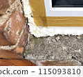 Window installation. The process of insulating windows with construction foam. A builder's hand seals the cracks between the building and the window frame. Construction and insulation of the building. 115093810