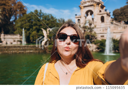 Young female tourist visiting Ciutadella Park in Barcelona. Young traveling woman taking selfie outdoors. Concept of travel, tourism and vacation in city. Use technology concept, Traveling Europe 115095635