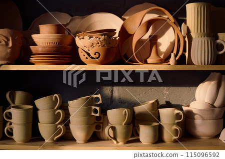 No people shot of stacks of handmade ceramic products on shelves in pottery workshop 115096592
