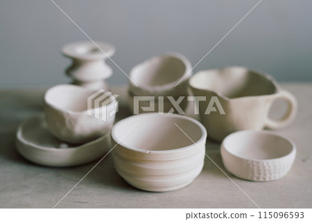 Closeup still life composition of handmade ceramic bowls and mug on table, copy space Closeup still life composition of handmade ceramic bowls and mug on table, copy space 115096593