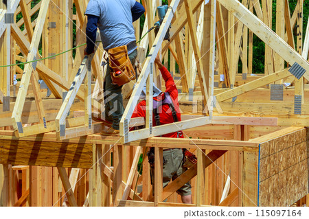 Installing beams using an air nail hammer on wooden plank frame by framer Installing beams using an air nail hammer on wooden plank frame by framer 115097164