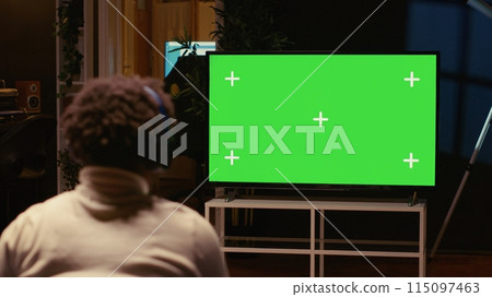Man playing singleplayer videogames on green screen TV in cozy living room used as home theatre. Gamer using controller to beat game on gaming console attached to mockup television set Man playing singleplayer videogames on green screen TV in cozy living room used as home theatre. Gamer using controller to beat game on gaming console attached to mockup television set 115097463