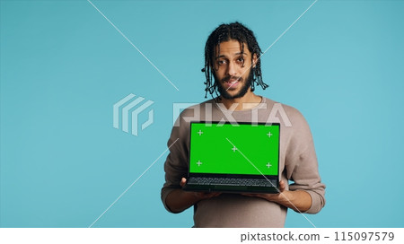 Joyous BIPOC man holding green screen laptop, having positive mood. Smiling person presenting chroma key notebook, doing recommendation, isolated over studio background, camera A Joyous BIPOC man holding green screen laptop, having positive mood. Smiling person presenting chroma key notebook, doing recommendation, isolated over studio background, camera A 115097579
