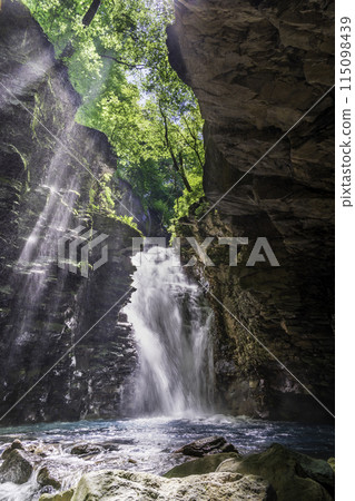 A ray of light shines through the fresh greenery of the Sukkansawa River at Yuhi Falls. A ray of light shines through the fresh greenery of the Sukkansawa River at Yuhi Falls. 115098439