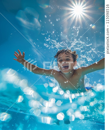 Energetic young boy having fun in a sunny swimming pool, photographed from an underwater angle Energetic young boy having fun in a sunny swimming pool, photographed from an underwater angle 115098516