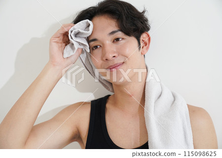 Young man wiping sweat with a towel after exercise Young man wiping sweat with a towel after exercise 115098625