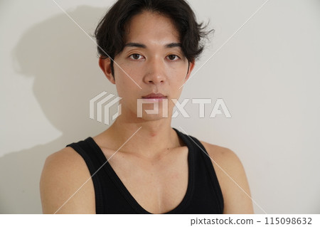 Young man wiping sweat with a towel after exercise 115098632