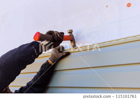 Damaged plastic siding of house is replaced during reconstruction of its exterior Damaged plastic siding of house is replaced during reconstruction of its exterior 115101761