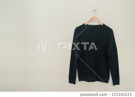 black sweater hanging on hanger 115103221