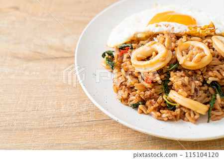 fried rice with squid and basil topped fried egg in Thai style fried rice with squid and basil topped fried egg in Thai style 115104120
