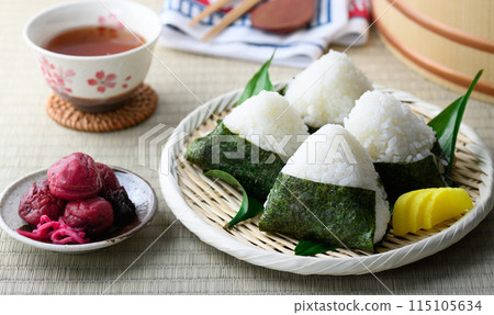 Rice balls wrapped in roasted seaweed and traditional sour pickled plums eaten on tatami mats Rice balls wrapped in roasted seaweed and traditional sour pickled plums eaten on tatami mats 115105634