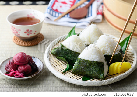 Rice balls wrapped in roasted seaweed and traditional sour pickled plums eaten on tatami mats 115105638