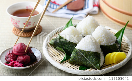 Rice balls wrapped in roasted seaweed and traditional sour pickled plums eaten on tatami mats 115105641