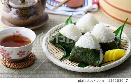 Rice balls wrapped in roasted seaweed and traditional sour pickled plums eaten on tatami mats Rice balls wrapped in roasted seaweed and traditional sour pickled plums eaten on tatami mats 115105647