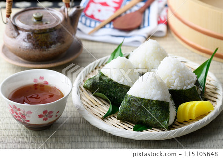 Rice balls wrapped in roasted seaweed and traditional sour pickled plums eaten on tatami mats 115105648