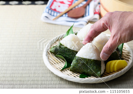 Rice balls wrapped in roasted seaweed and traditional sour pickled plums eaten on tatami mats 115105655