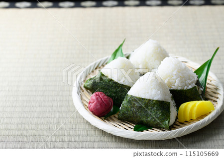Rice balls wrapped in roasted seaweed and traditional sour pickled plums eaten on tatami mats Rice balls wrapped in roasted seaweed and traditional sour pickled plums eaten on tatami mats 115105669