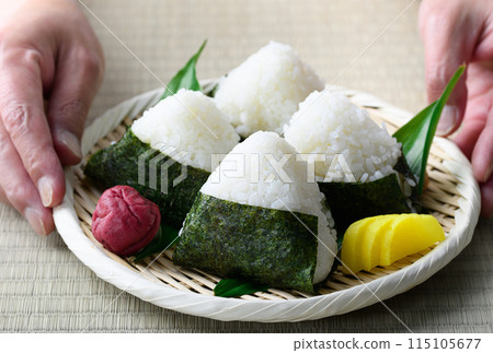 Rice balls wrapped in roasted seaweed and traditional sour pickled plums eaten on tatami mats Rice balls wrapped in roasted seaweed and traditional sour pickled plums eaten on tatami mats 115105677