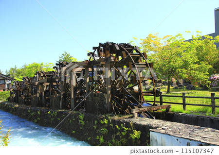 A five-wheel waterwheel shining amidst fresh greenery A five-wheel waterwheel shining amidst fresh greenery 115107347