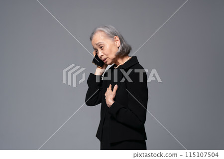 穿著喪服的高級女性在智慧型手機上交談 115107504
