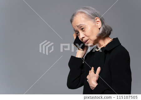穿著喪服的高級女性在智慧型手機上交談 115107505
