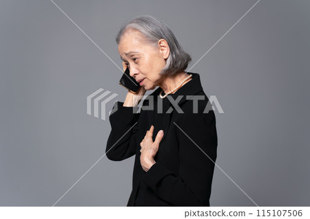 穿著喪服的高級女性在智慧型手機上交談 115107506