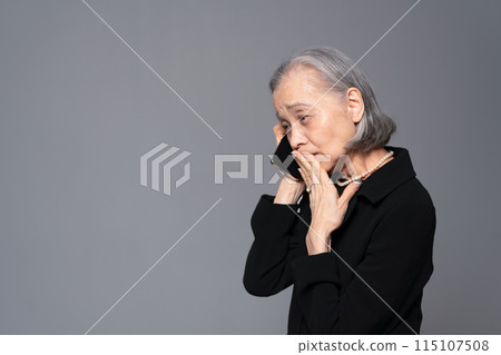 穿著喪服的高級女性在智慧型手機上交談 115107508