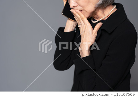 穿著喪服的高級女性在智慧型手機上交談 115107509