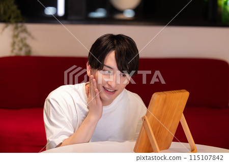 Living room at night: A young man doing skin care 115107842