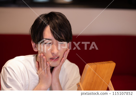 Living room at night: A young man doing skin care Living room at night: A young man doing skin care 115107852
