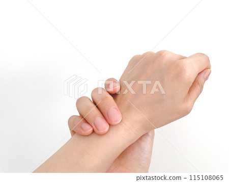 A woman's hand holding her left wrist with her right hand 115108065