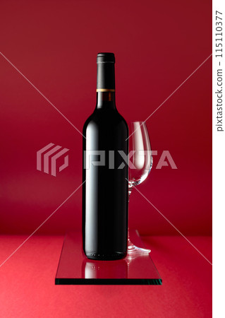 Bottle of red wine and an empty wine glass. Bottle of red wine and an empty wine glass. 115110377