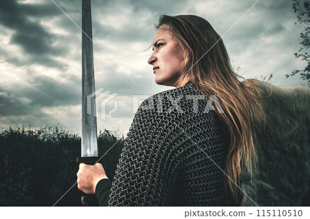 Portrait of woman in image of medieval warrior under dramatic sky. Portrait of woman in image of medieval warrior under dramatic sky. 115110510