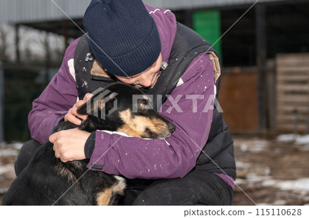 Girl volunteer in the nursery for dogs. Shelter for stray dogs. 115110628