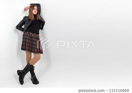 Teenager girl in a skirt posing in the studio on a white background. Full length portrait of a girl wearing plaid skirt 115110869