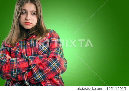 Portrait of sad unhappy teenage girl. Studio shot. Isolated on green background. . Portrait of sad unhappy teenage girl. Studio shot. Isolated on green background. . 115110915