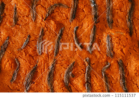 Orange freshly baked pumpkin pie with anchovies. Top view  115111537