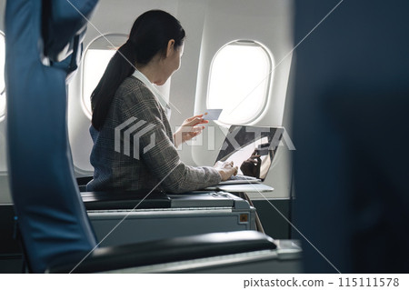 Businesswoman making online purchase during flight, Concept of work-life balance 115111578