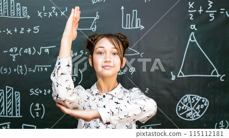 Schoolgirl raises her hand to answer teacher's question Schoolgirl raises her hand to answer teacher's question 115112181