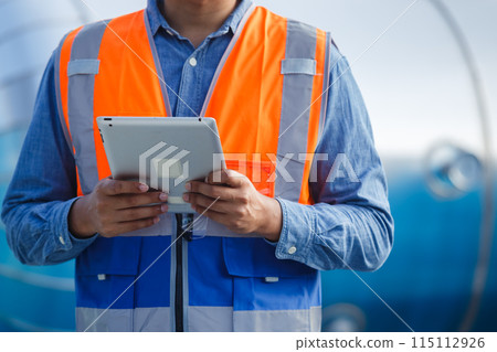 close up tablet with man engineer working at rooftop building. 115112926