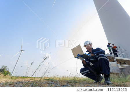 Team engineer wearing safety uniform holding laptop discussed plan about renewable energy at station Team engineer wearing safety uniform holding laptop discussed plan about renewable energy at station 115113953